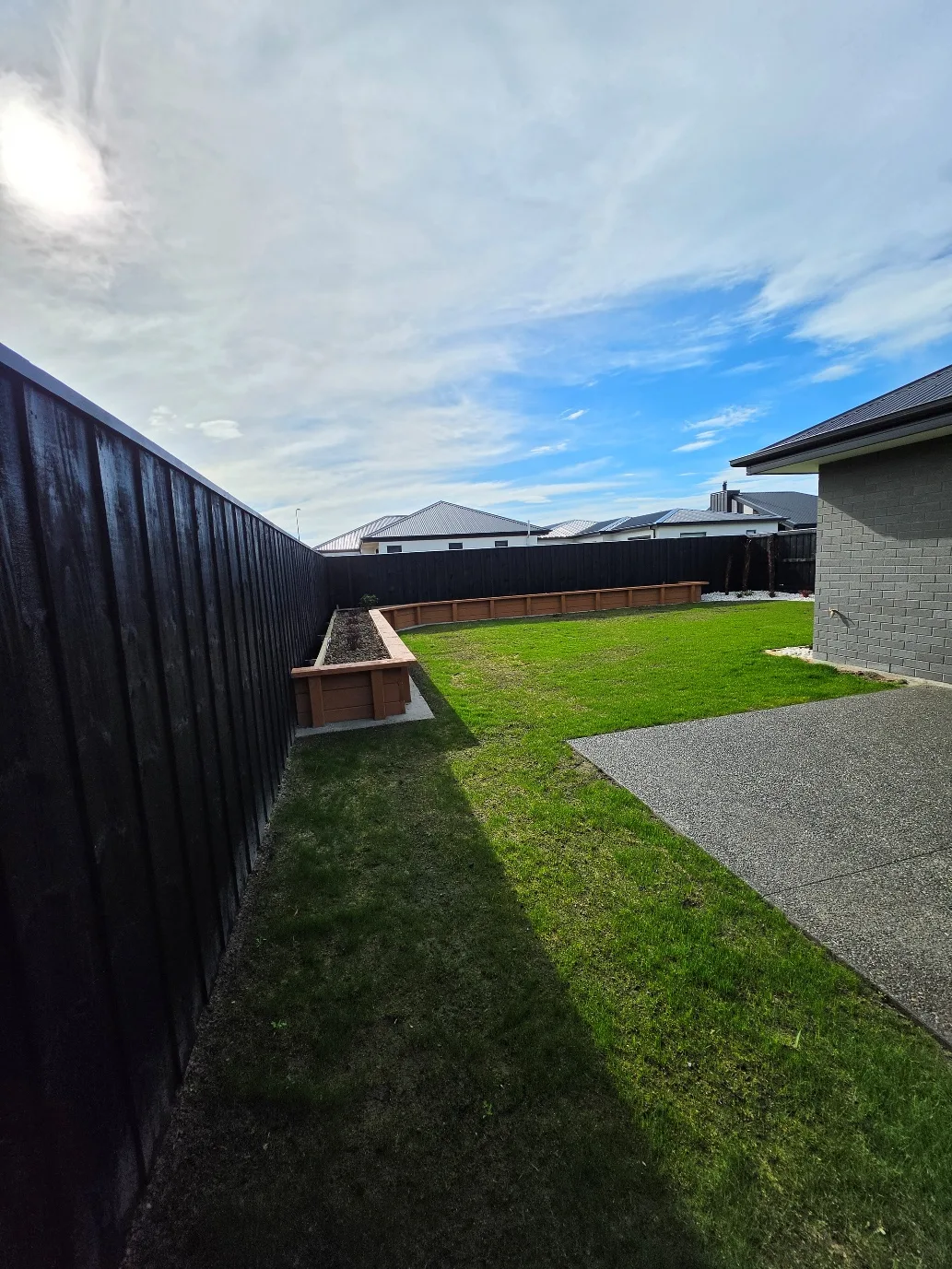 Raised timber planter beds, fresh lawn and aggregate paving at 25 Derbridge Street